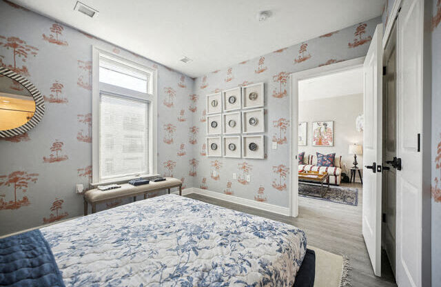 a bedroom with a bed and a wall of framed pictures