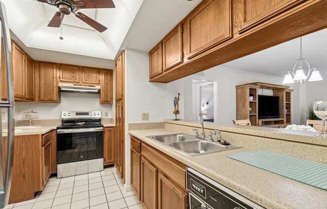 A kitchen with wooden cabinets and a tile floor at Hampton Apartments, Clearwater, FL