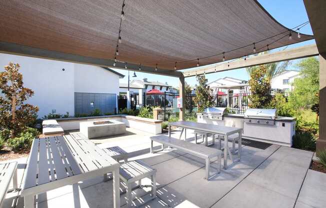 A patio with a table and chairs under a shade sail.