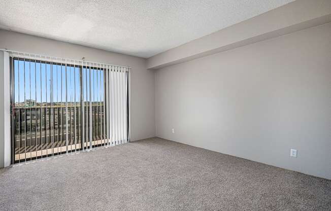 an empty living room with blinds on a window