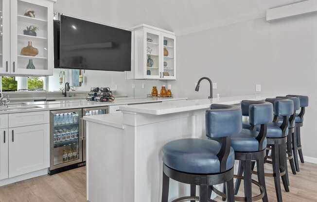 a kitchen with a breakfast bar and a flat screen tv