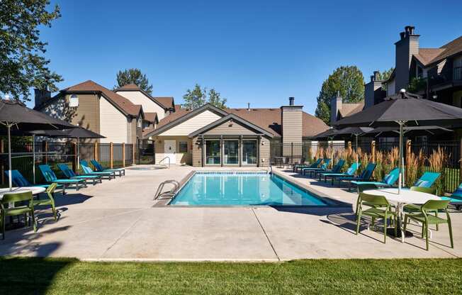 a swimming pool with blue chaise lounge chairs and umbrellas