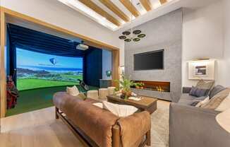 a living room with a couch and a tv and a view of the golf course