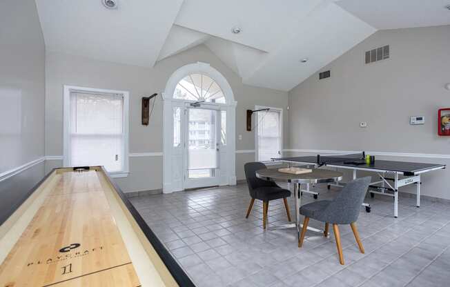 a dining area with a table and chairs and a ping pong table in a