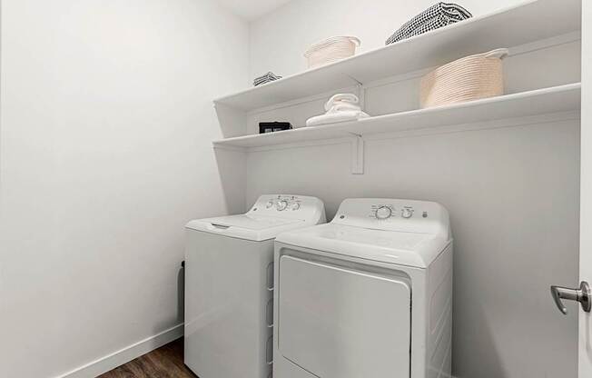 A white laundry room with a washer and dryer.