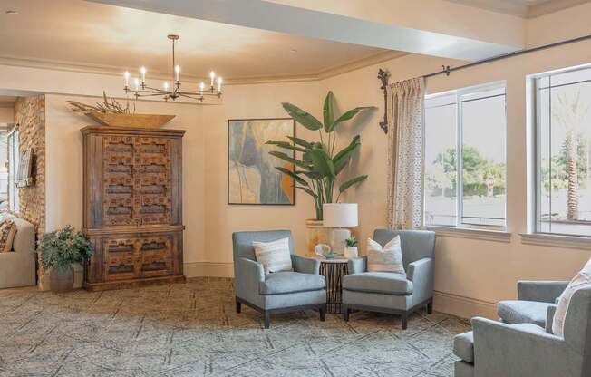 A living room with a grey sofa, a wooden cabinet, and a painting on the wall.