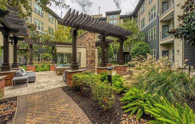 a courtyard with a pergola in front of an apartment building