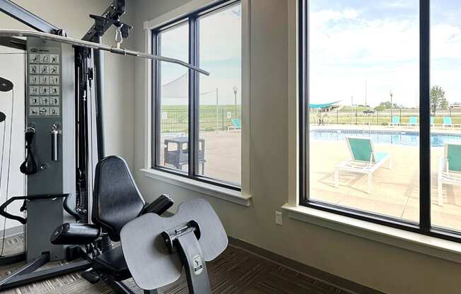 A gym with a view of a pool and a track.