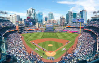 a view of a baseball stadium with a city in the background