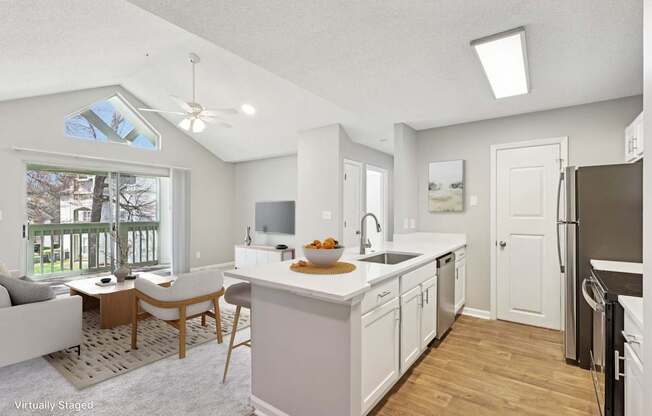 A kitchen with white cabinets and a wooden island.
