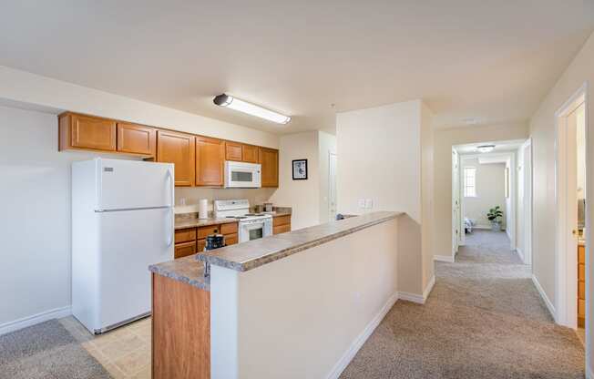 a long kitchen with white appliances and a granite counter top  at Quail Springs, West Richland, WA, 99353