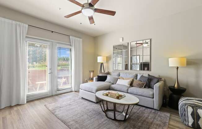 a living room with a couch and a ceiling fan at Apartments at Ridge at Thornton Station Apartments, Thornton, CO 80229