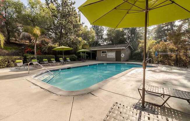 A yellow umbrella is next to a pool.