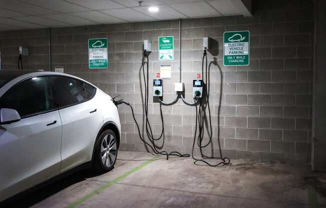 a car plugged into a charging station in a parking garage