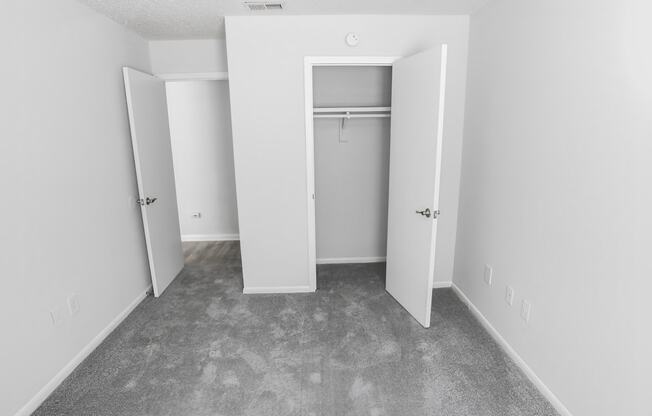 an empty room with white walls and a closet