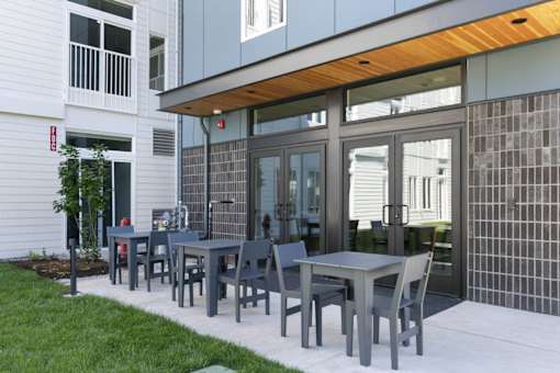 A patio with a table and chairs is in front of a building.
