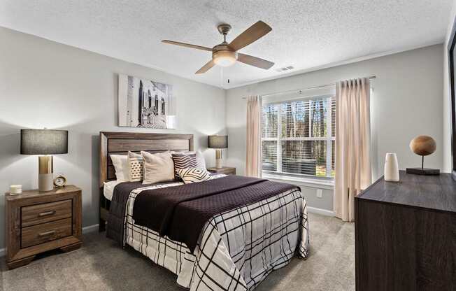 A bedroom with a bed, nightstand, and a ceiling fan.