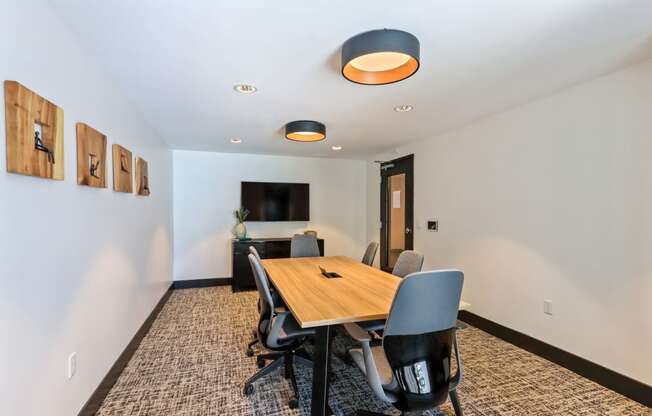 Meeting room with a wooden table and chairs and a flat screen tv on the wall at Array La Mesa, La Mesa California