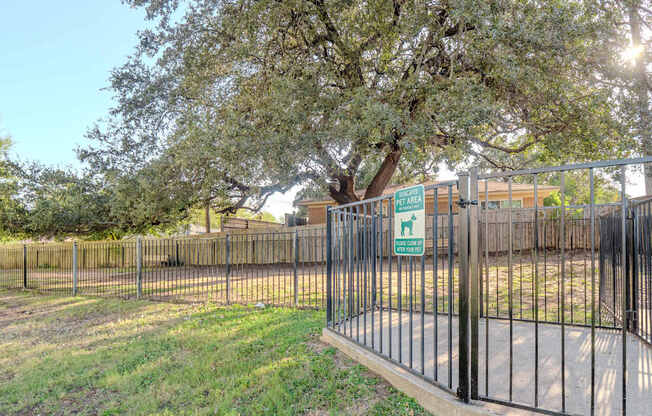 a fence with a tree behind it and a sign on it