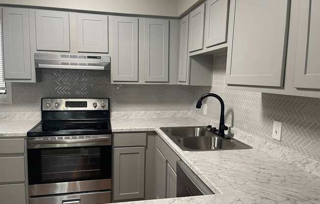 A kitchen with a stove top oven and a sink.