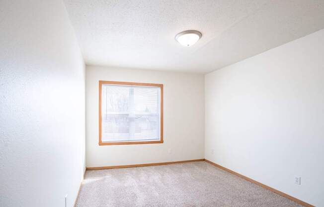 A room with a window and carpet on the floor. West Fargo, ND Sheyenne Terrace Townhomes