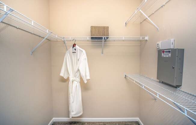 a spacious closet with a robe and a clothes rack