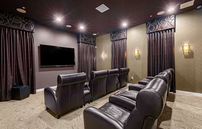 a large screening room with leather seats and a large screen tv