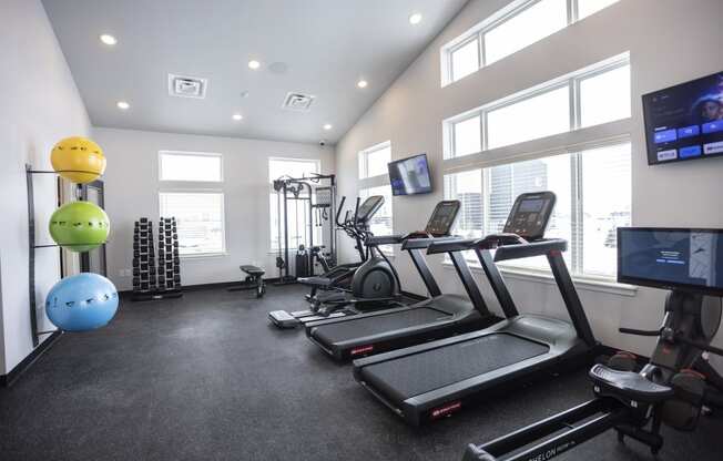 Modern gym with rows of cardio equipment.