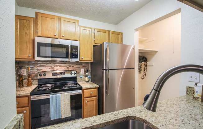 This is a photo of the kitchen in the 692 square foot 1 bedroom model apartment at Cambridge Court Apartments in Dallas, TX.