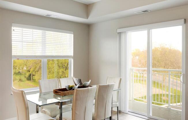 A dining room with a glass table and chairs.