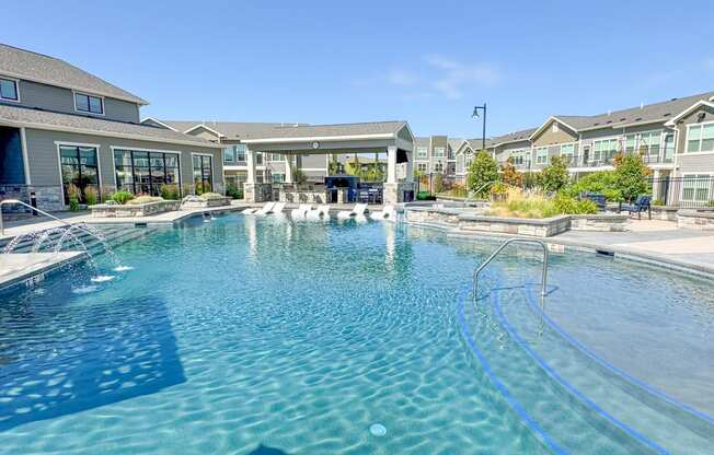 a large swimming pool with apartments in the background