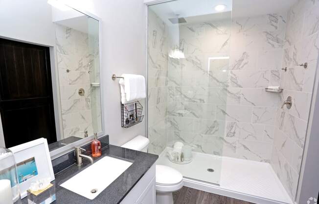 a bathroom with a shower and a sink and a mirror at Century Baxter Avenue, Louisville, KY 40204