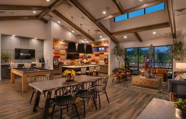 a dining room with a table and chairs and a kitchen with a large windowat Weylyn Luxury Apartments, Laveen, AZ