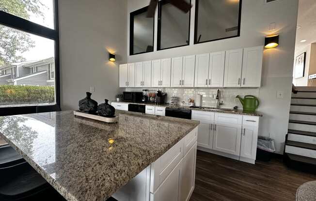 a kitchen with white cabinets and a granite counter top