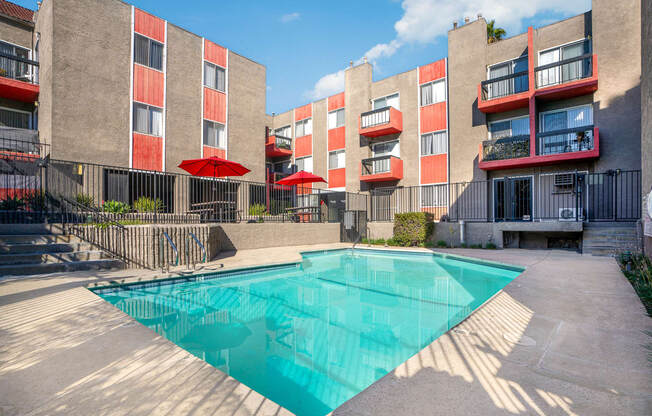 an apartment building with a pool in front of it