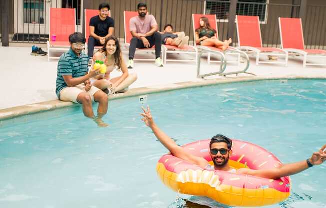 a man swimming in a pool with a floatie at Dwell