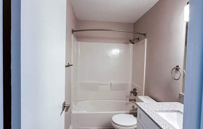 A small bathroom with a toilet, sink and shower.