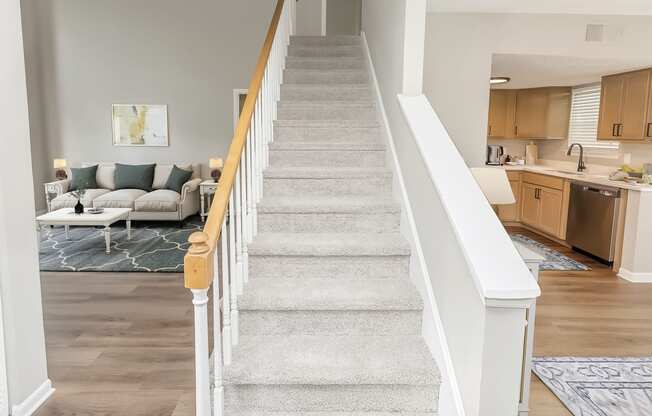 a staircase dividing the living room and kitchen