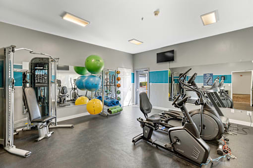 a gym with cardio equipment and weights  at Camelot Apartment Homes, Everett, WA, 98204