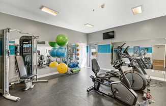 a gym with cardio equipment and weights  at Camelot Apartment Homes, Everett, WA, 98204
