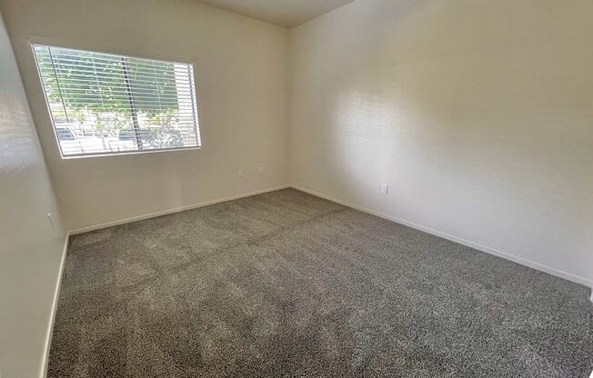 an empty room with carpet and a window