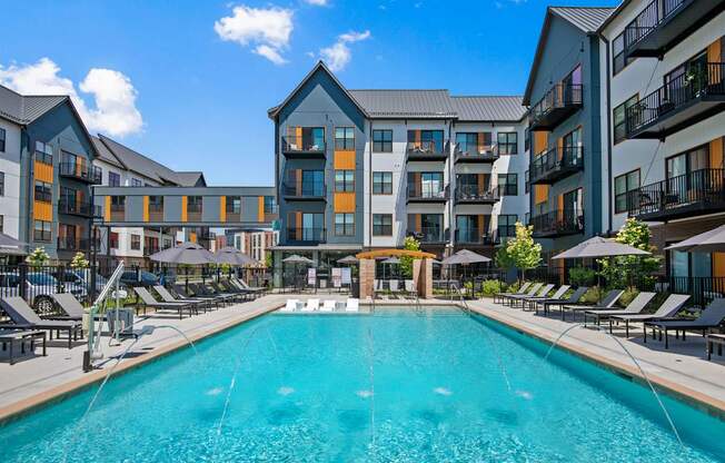 A large swimming pool in front of apartment buildings.