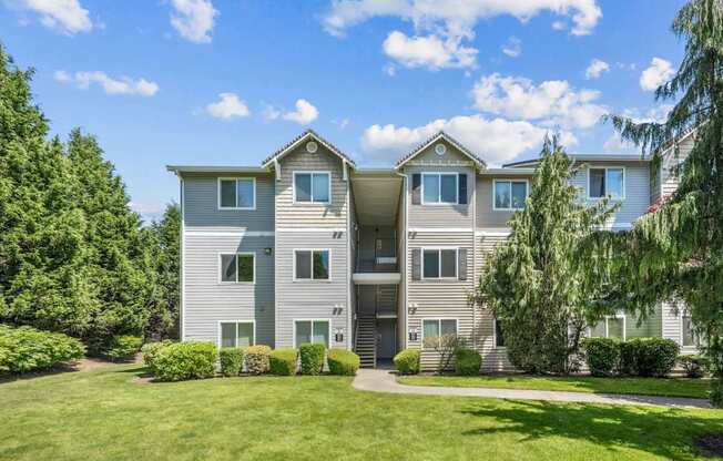 Apartment exteriors with lush greenery at The Madison apartments in Olympia, WA