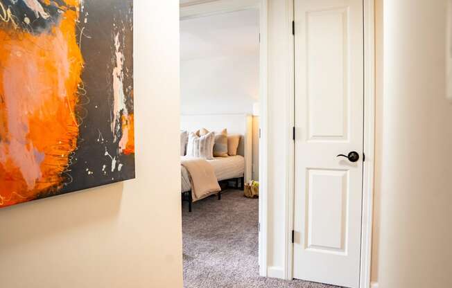 a doorway to a bedroom with a large painting on the wall