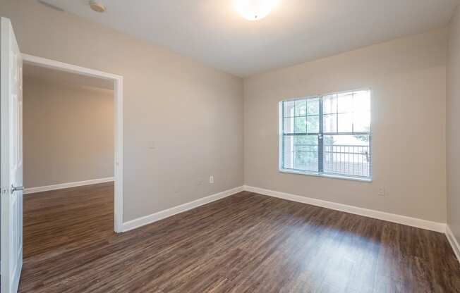 an empty living room with wood flooring and a window at Crogman School Lofts, Atlanta Georgia