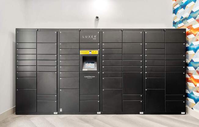 A wall of black lockers with one open and a yellow sign on it.