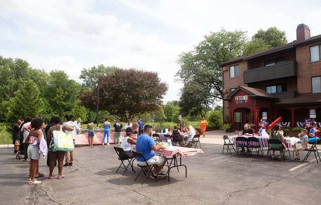 a large group of people sitting at tables outside of a building