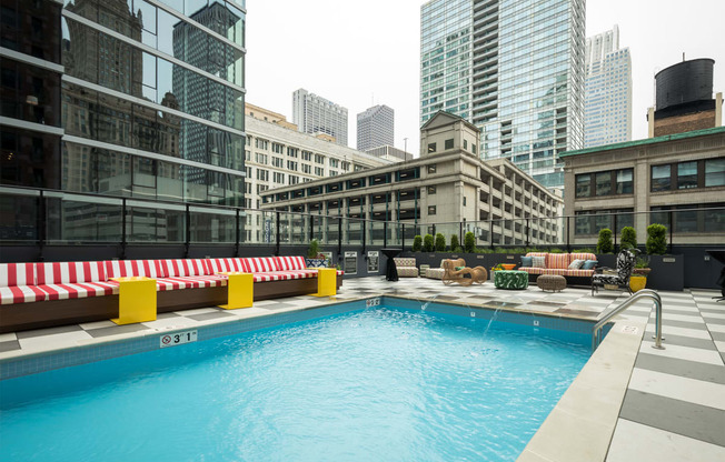 a swimming pool on the rooftop of a building with skyscrapers