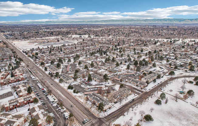 A snowy day in a residential area with houses and roads.
