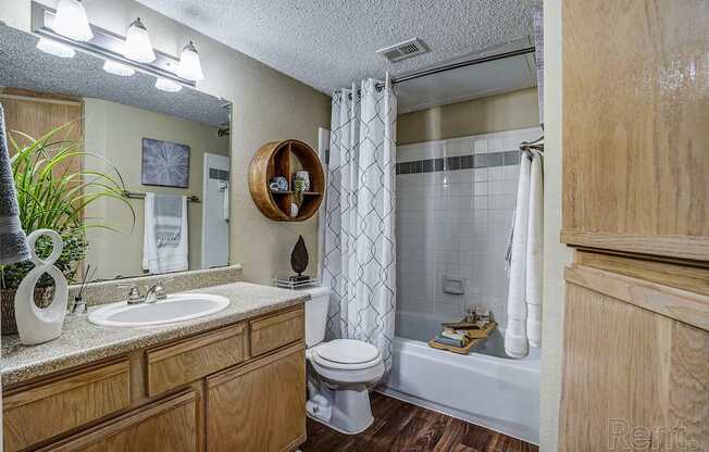 A bathroom with a toilet, sink, and bathtub.